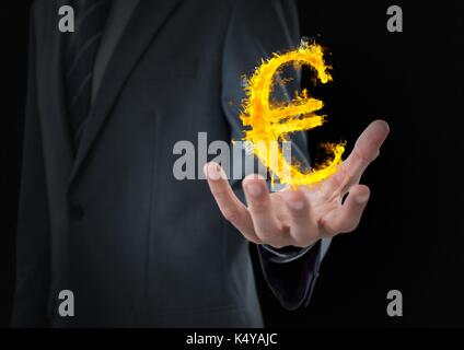 Digital composite of hand with euro  fire icon over. Black background Stock Photo