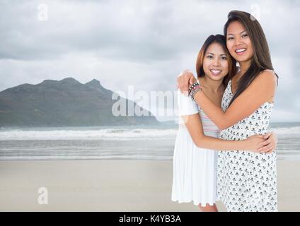 Digital composite of Best friends hugging against blurry beach Stock Photo