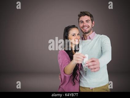 Digital composite of Couple Holding key in front of vignette Stock Photo
