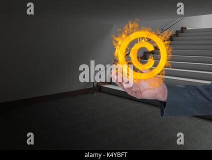 Digital composite of hand  with copyright fire icon over in office Stock Photo