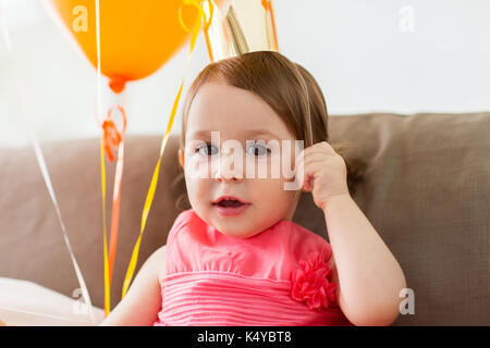 happy baby girl in crown on birthday party at home Stock Photo