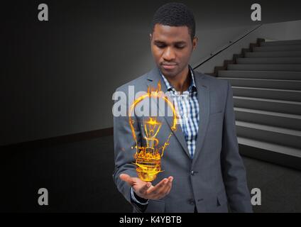 Digital composite of businessman with hand spread of  with light fire icon over in the office. Stock Photo