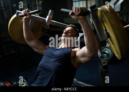 man doing chest press on exercise machine in gym Stock Photo