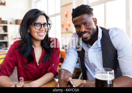 happy man and woman with smartphone at bar Stock Photo
