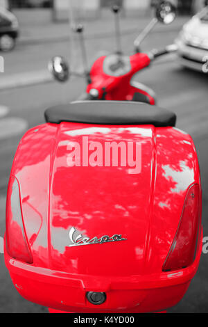 A red Vespa scooter parked in the Boulevard de Clichy, Montmartre, Paris against a black and white background Stock Photo