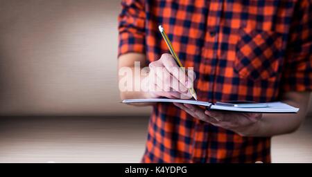 Digital composite of Millennial man mid section with notepad in pink room Stock Photo