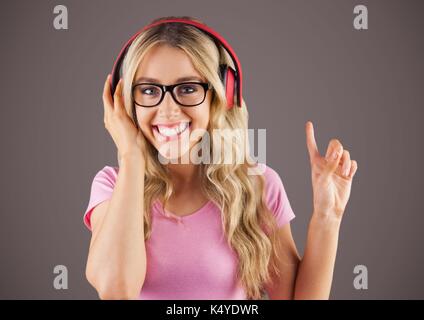 Digital composite of Millennial woman with headphones against brown background Stock Photo