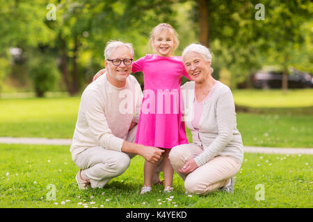 senior grandparents and granddaughter at park Stock Photo