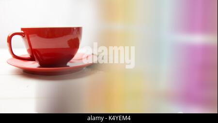 Digital composite of Red coffee cup with beans and blurry rainbow transition Stock Photo