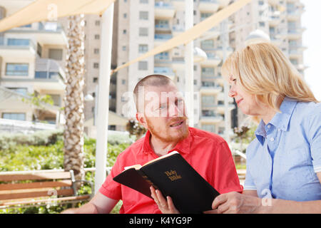 We studying Holy Bible together. Disabled man. Stock Photo