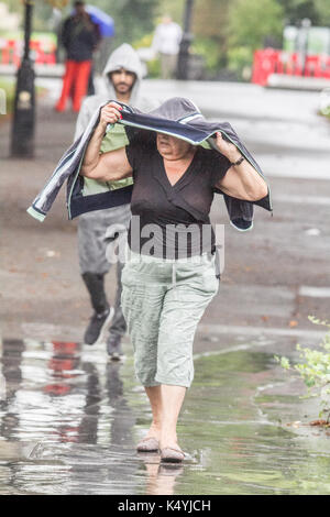 London, UK. 7th Sep, 2017. A woman shelters from the rains in Regents Park as the wet weather arrives in London Credit: amer ghazzal/Alamy Live News Stock Photo