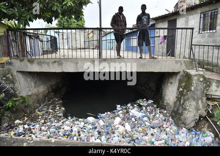 Santo Domingo, Dominican Republic. 7th Sep, 2017. Two men look at plastic bottles that have piled up under a bridge after hurricane 'Irma' has passed the city of Santo Domingo, Dominican Republic, 7 September 2017. The extent of damage in the city is unclear until now. 'Irma' is creating a path of destruction in the Carribean. Photo: Bayoan Freites/dpa/Alamy Live News Stock Photo