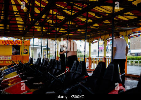 Worthing, West Sussex, UK. 8th Sept, 2017. A weather beaten dodgems ride on Worthing Seafront on Friday 8 September 2017 held at Seafront, Worthing. The ride came to Worthing as part of a traveling funfair but has remained in place after the rest of the fair moved on in August. The weather has taken its toll on the roof and structure. Pictured: Runners shelter from a sharp rain downpour. Credit: Julie Edwards/Alamy Live News Stock Photo