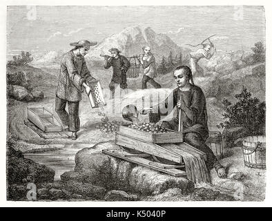 Ancient chinese miners sifting and washing gold-bearing sand, outdoor in California. Created by Chassevent after previous engraving by unknown author published on Le Tour du Monde Paris 1862 Stock Photo