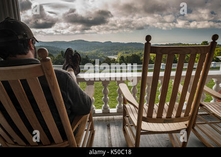Feet Up Relaxing Rocking Chair Front Porch - Amazing View, Clouds. Southern Mountain Living at It's Best. Wooden Rockers on Porch Overlooking Lake Stock Photo