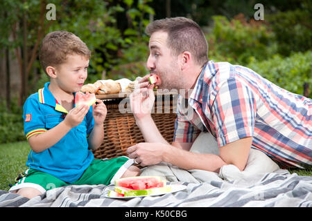 Father and son eating watermelon Stock Photo