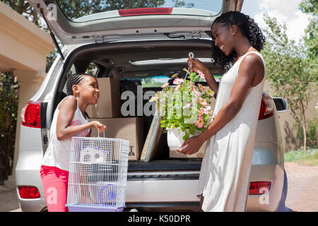 Daughter with mother outside car Stock Photo