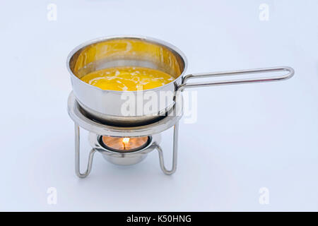 melting butter in a small pan on a tealight Stock Photo