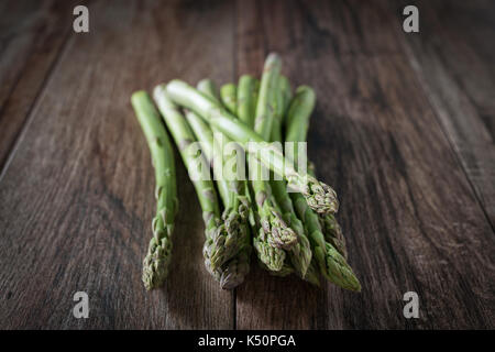 Closeup shot of fresh asparagus bunch on wooden rustic background Stock Photo
