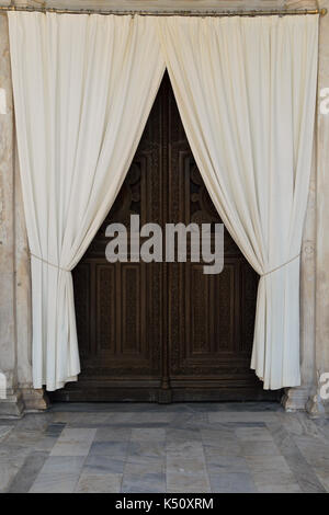 Wooden carved church gate and drapes. Metropolitan cathedral of Athens, Greece. Stock Photo