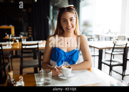 Woman drinking coffee in restaurant Stock Photo