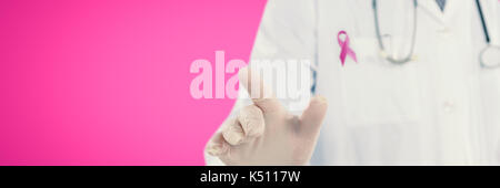 Doctor touching an digital screen  against pink background Stock Photo