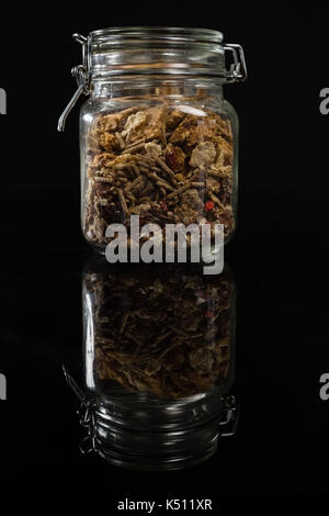 Mixed breakfast cereals in glass jar on black background Stock Photo