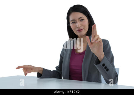 Businesswoman touching invisible screen against white background Stock Photo
