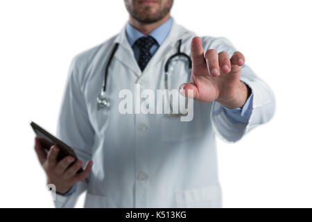 Male doctor using invisible screen against white background Stock Photo