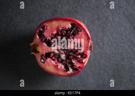 Overhead view of pomegranate on gray slate Stock Photo
