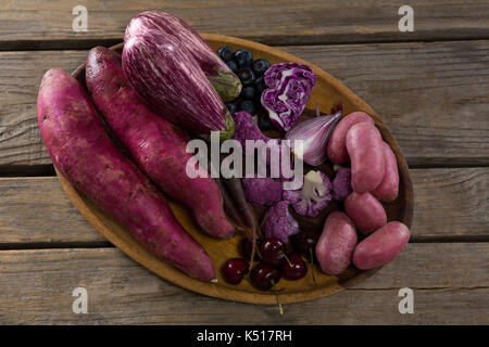 Close-up of various vegetables in a tray on wooden table Stock Photo