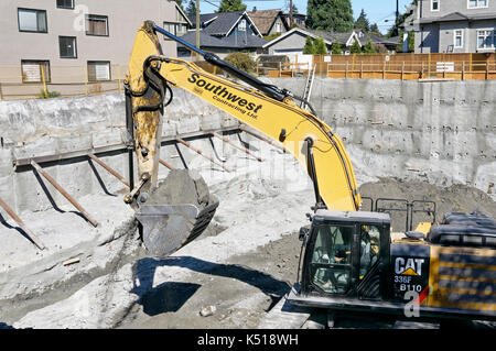 Caterpillar 336F  hydraulic excavator digging foundations for a new residential building in Kerrisdale, Vancouver, BC, Canada Stock Photo