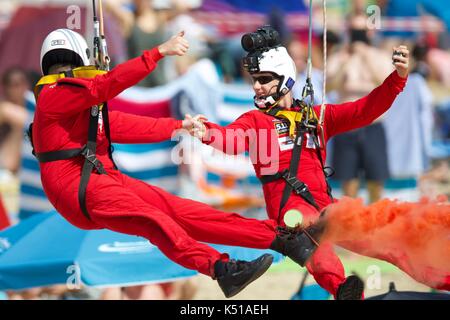 Two members of the Red Devils Parachute Team enjoying a ride on the Bournemouth Zip Wire Stock Photo
