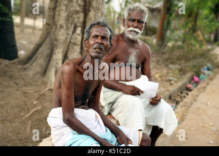 Old man enjoys sitting on a bench. Stock Photo