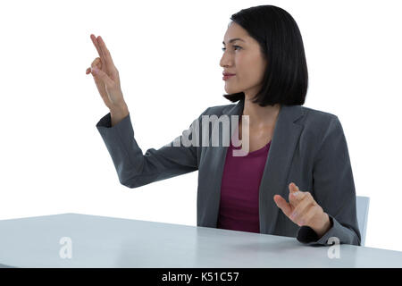 Businesswoman touching invisible screen against white background Stock Photo