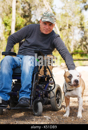 Disabled man in a wheelchair with his faithful dog Stock Photo