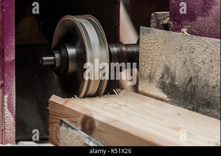 The machine for sampling the groove in a wooden beam with a milling cutter for vertical grooving Stock Photo