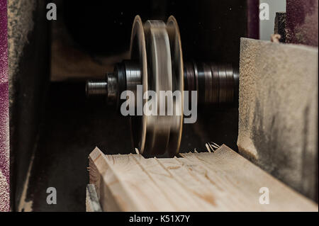 The machine for sampling the groove in a wooden beam with a milling cutter for vertical grooving. in start of progress Stock Photo