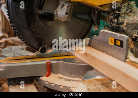 Circular saw with a wooden beam and measuring scale. Sawing a wooden beam with a circular saw. Stock Photo