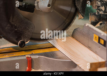Circular saw with a wooden beam and measuring scale. Sawing a wooden beam with a circular saw. closeup Stock Photo