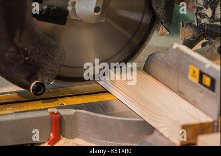 Circular saw with a wooden beam and measuring scale. Sawing a wooden beam with a circular saw. another view Stock Photo