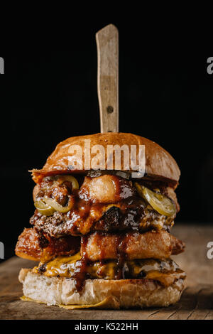Double Meat Burger with fried onion rings, cheese and pickled jalapenos Stock Photo