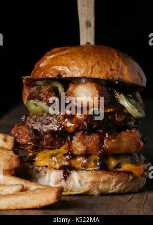 Double Meat Burger with fried onion rings, cheese and pickled jalapenos Stock Photo