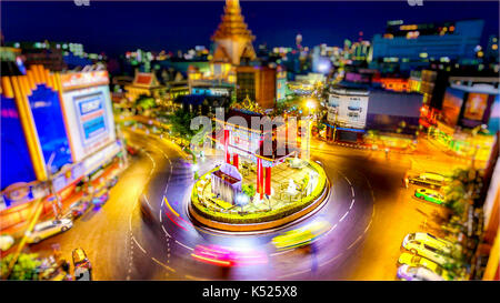 Bangkok skyline at sunset and China Gate at the entrance to Chinatown in Bangkok, Thailand (logos blurred for commercial use) Stock Photo