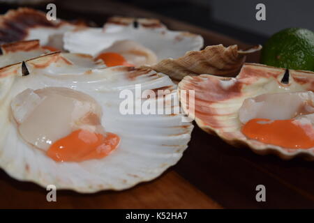 Close up of uncooked scallops on a wooden board Stock Photo