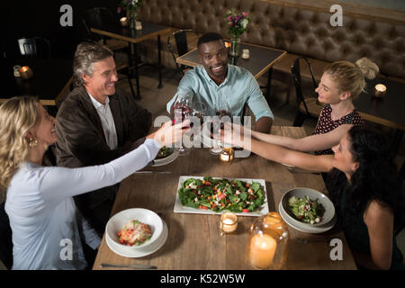 Overhead of happy friends toasting wine in restaurant Stock Photo
