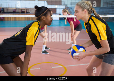Female players looking face to face while playing volleyball in the court Stock Photo