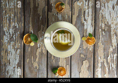 Overhead view of lemon and mint leaves in ginger tea on weathered table Stock Photo