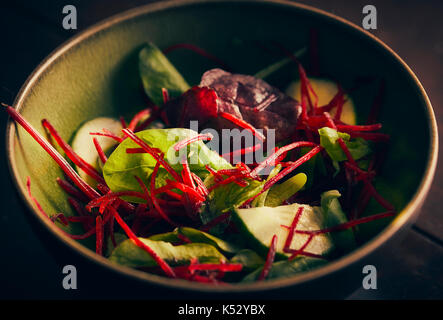 Shredded beetroot salad with lettuce leaves and cucumber close up Stock Photo
