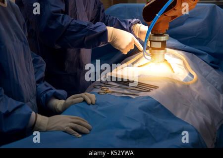 Smart healthcare technology , artificial intelligence concept. Selective focus on automation robot hand machine in operating room and surgery doctors  Stock Photo